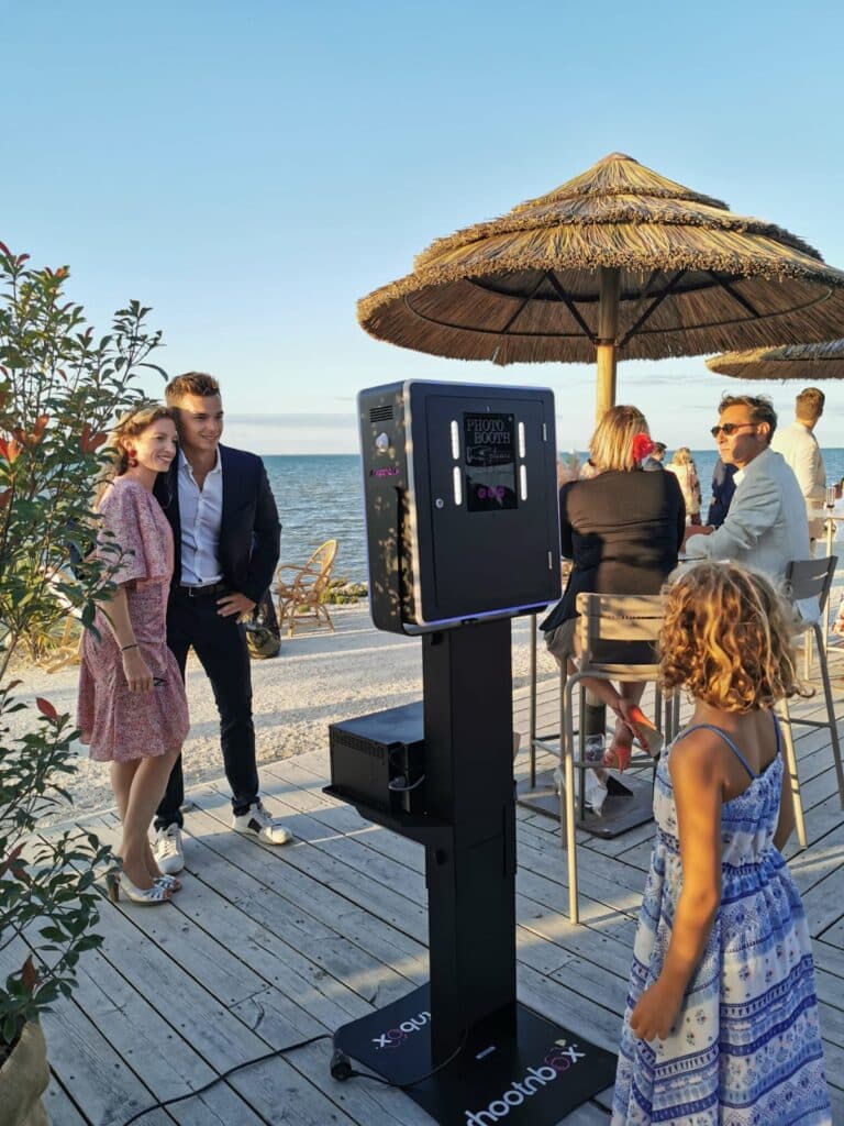 photo booth double côté un couple devant la plage mer soleil couchant et petite fille enfant