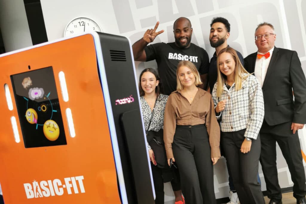 location Photobooth prenant en photo Teddy Riner lors d'un évènement d'entreprise chez Basic Fit. La borne photo personnalisé au couleur orange de basic fit