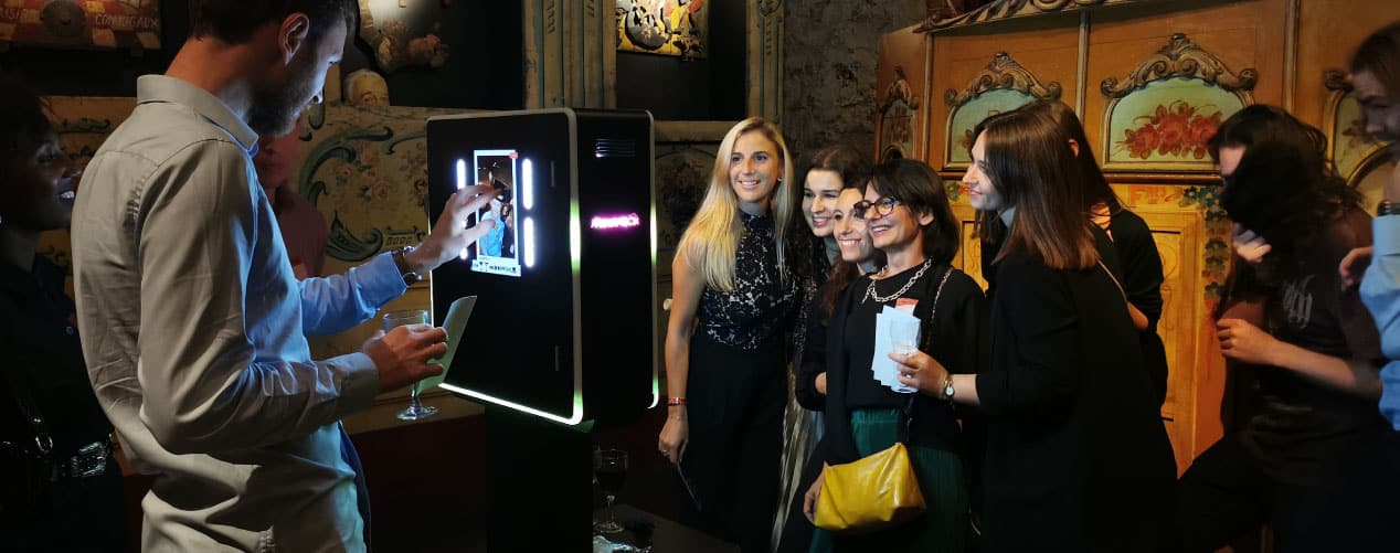 Homme et femmes devant un borne photo