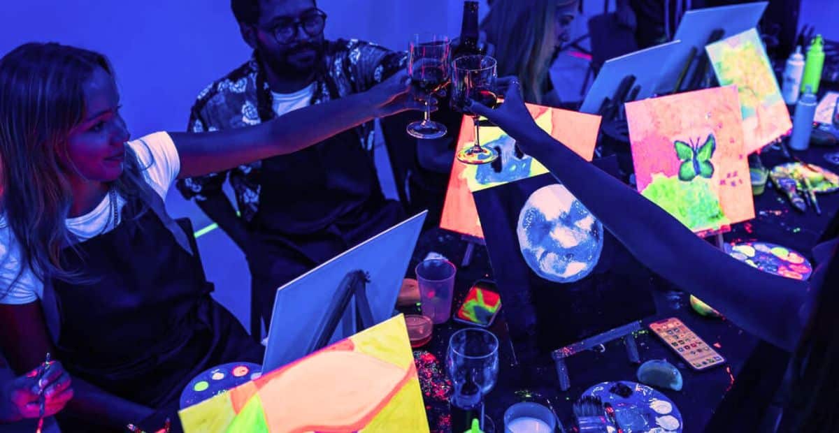 groupe amis participe à un atelier peinture dans le noir glow in the dark tableau fluo réfléchissant