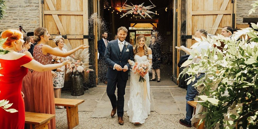 célébration sortie mariés riz homme costume femme robe mariée mariage champetre grange