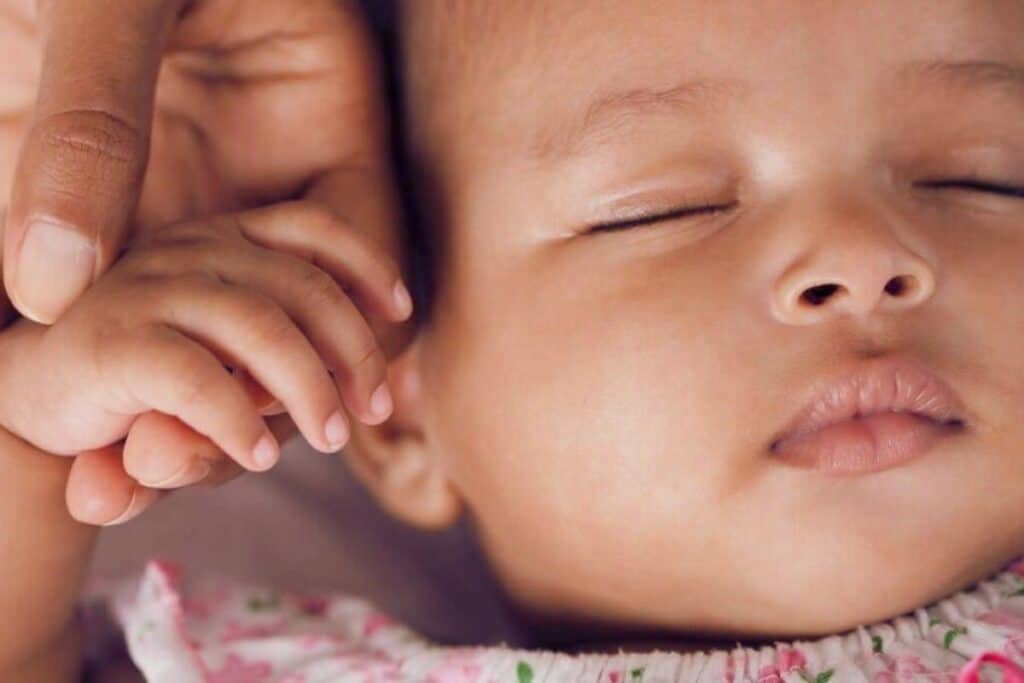 bébé métisse qui dort enfant dodo petite main maman