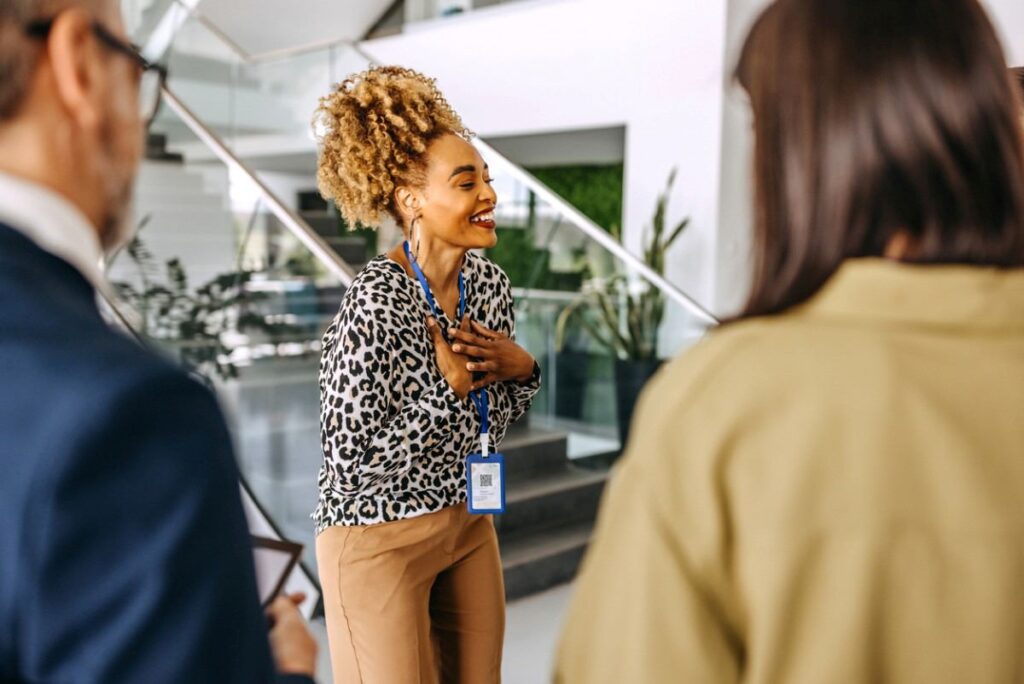 collegue femme en entreprise émue par son départ discours touchant badge autour du cou