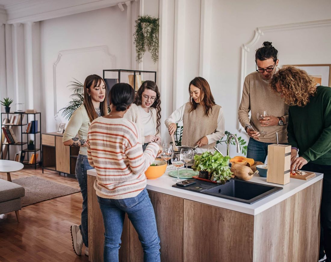amis autour ilot entral preparation cuisine invités pendaison crémaillère appartement décoration moderne minimaliste