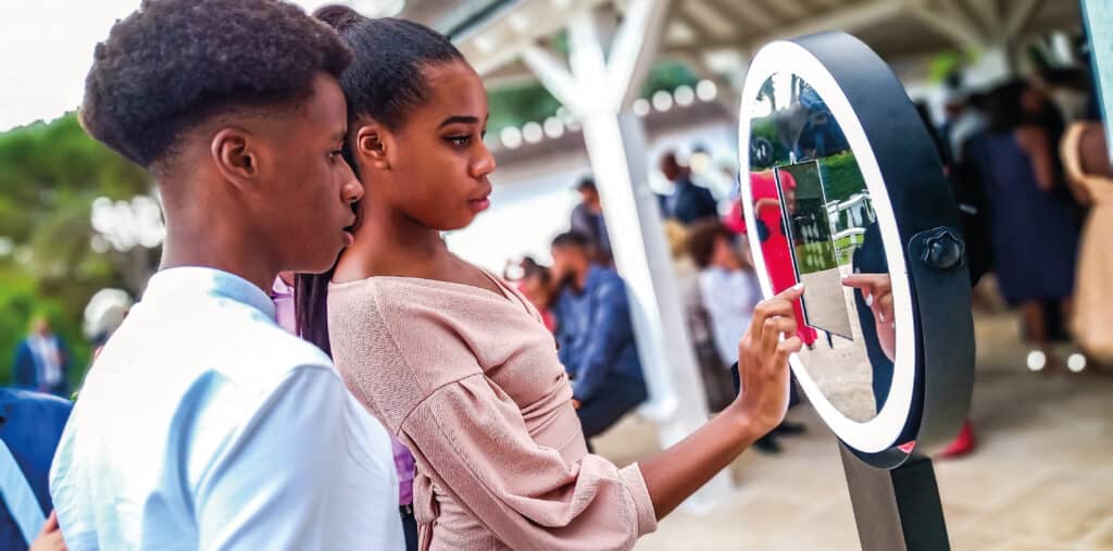 Homme et femme devant une borne photo pendant un mariage