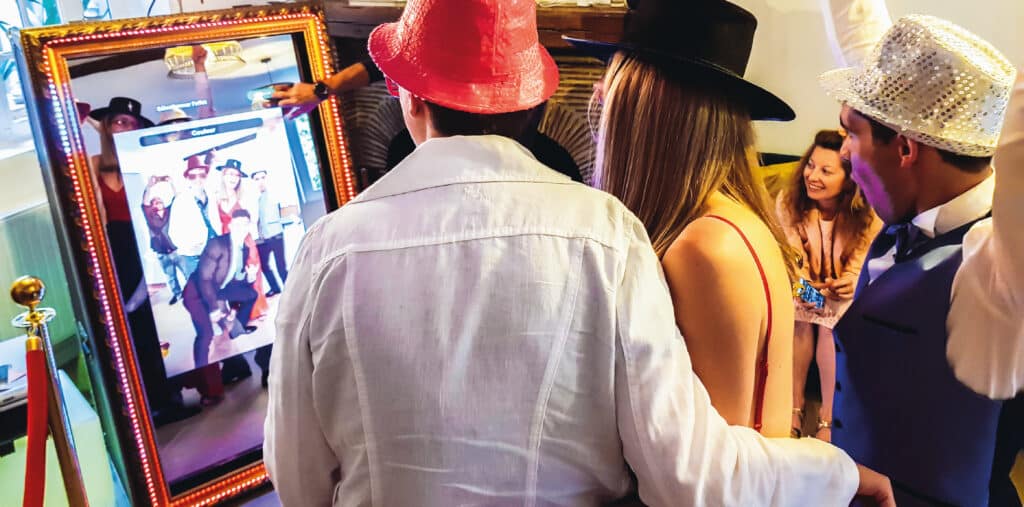 Hommes et femmes devant borne photo miroir pendant un mariage