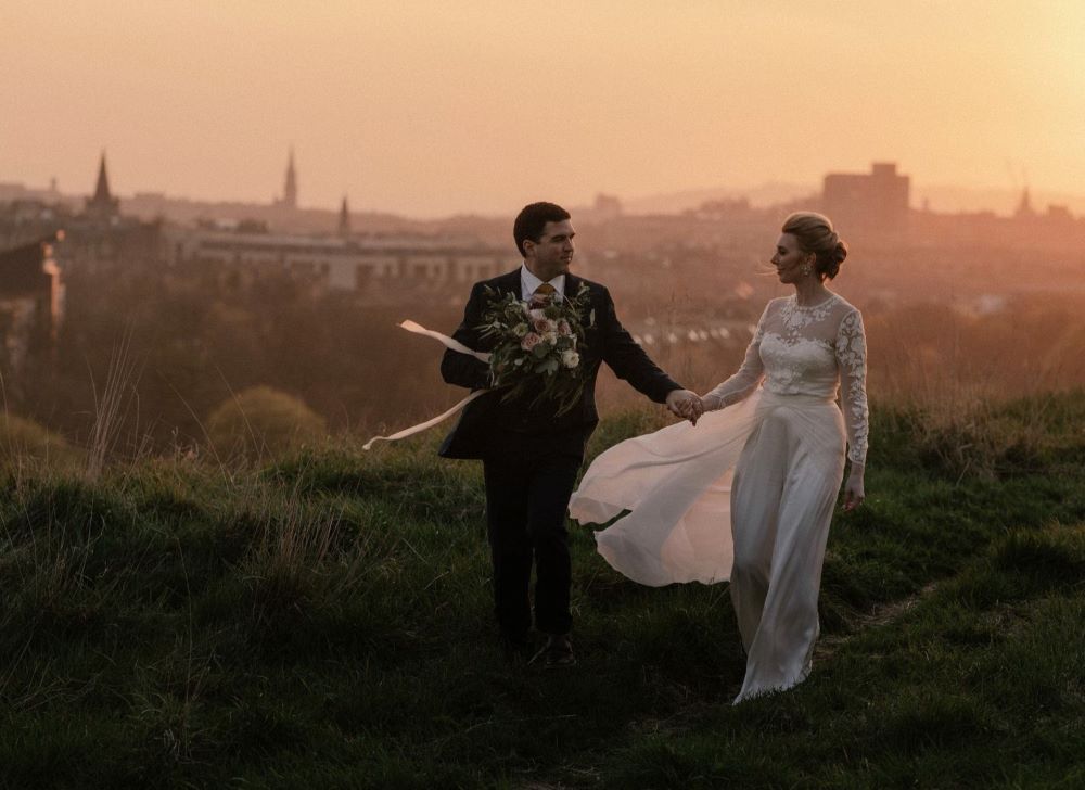 photo des mariés prise en hauteur de la ville écosse skyline tombée de la nuit golden hour