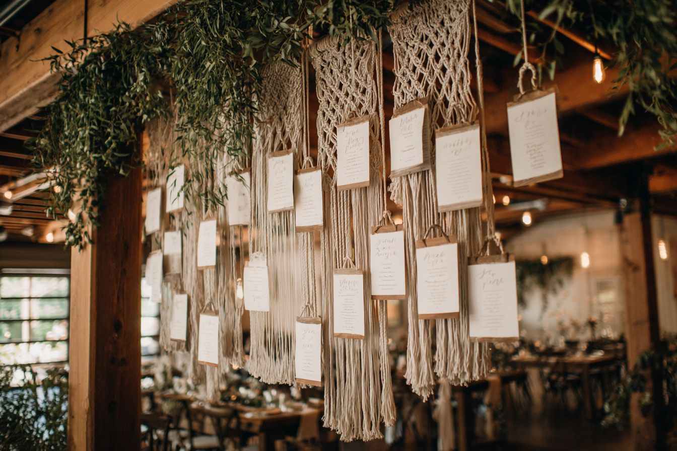 Plan de table mariage bohème suspendu en macramé avec panneaux tissus et lettrage artisanal