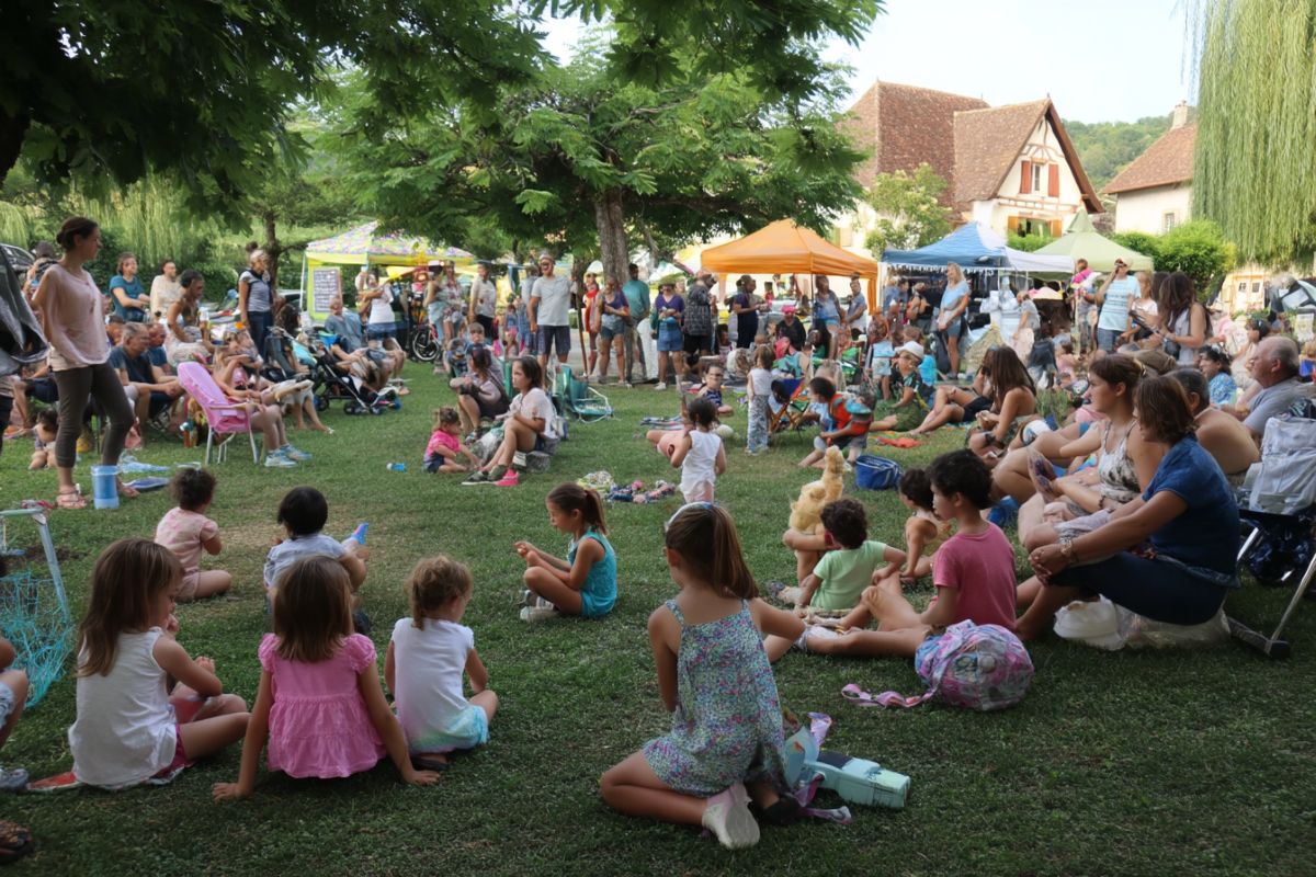 fête de village campagne jardin rempli d'enfant assis dans l'herbe animation