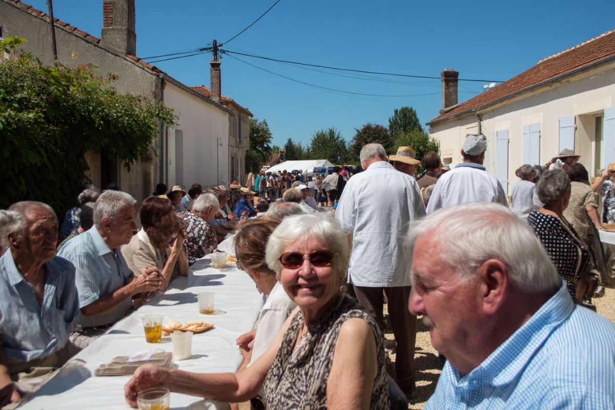 repas de village traditionnel en extérieur grande table avec personne âgées habitants locaux animation fête