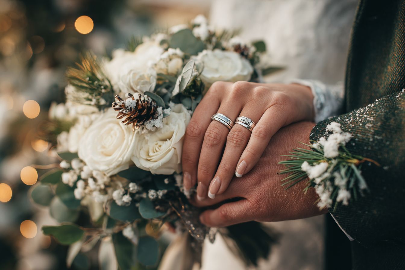 couple mariés se tenant par la main alliances bouquet de fleur naturel hiver pin