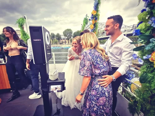 mariage péniche invités se prennent en photo devant photobooth shootnbox